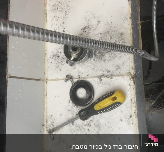 מברג וכלי אינסטלציה על רצפת אריחים